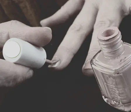 Close-up of a person's hands as they paint their nails with nailpolish