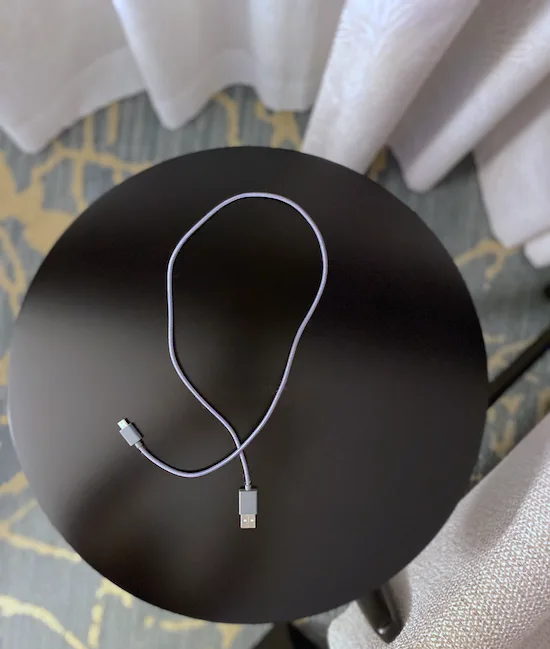 A cable in the shape of a loop lying on top of a round tabletop.