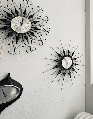 Three 1950's clocks hanging on a wall.