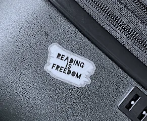 A sticker on top of a suitcase that says Reading Is Freedom.