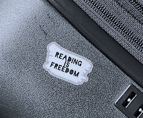 A sticker on top of a suitcase that says Reading Is Freedom.